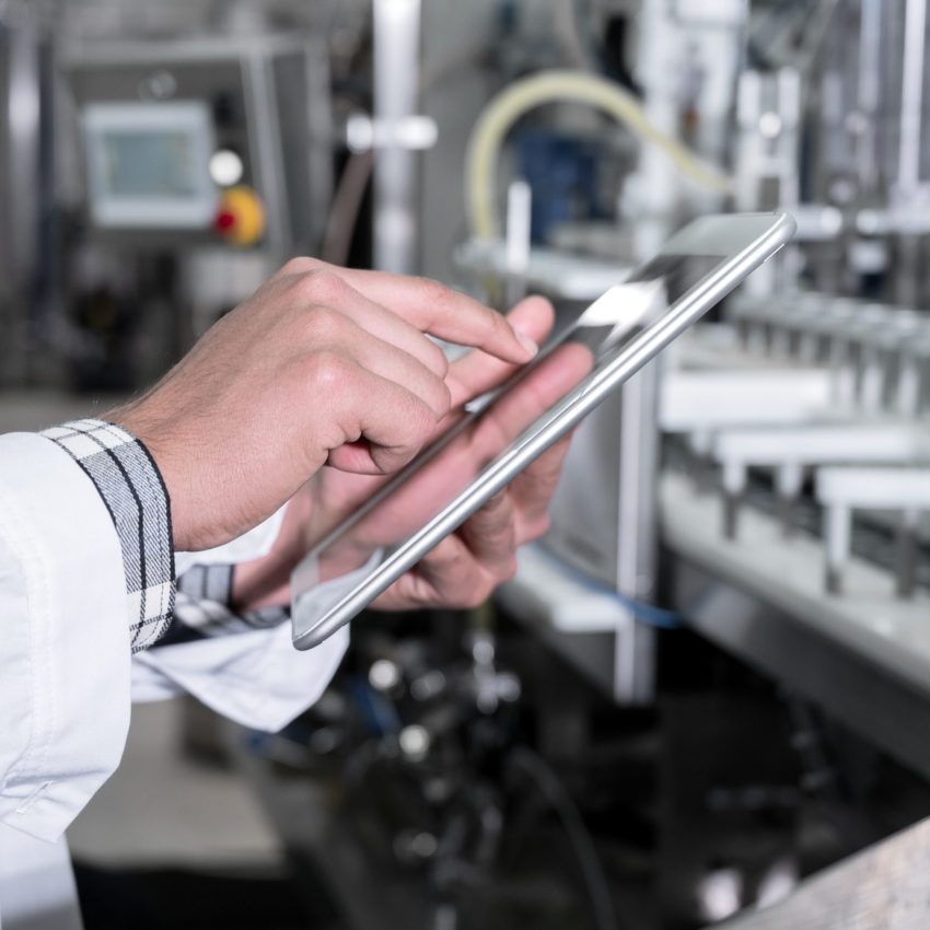 Factory worker inspecting production line on beverage factory with computer tablet. High quality photo